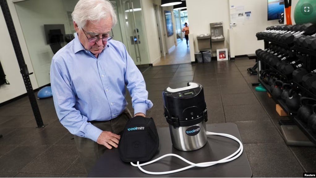 Craig Heller, a professor of biology at Stanford University, tries on the CoolMitt device in a gym, in Menlo Park, California, U.S. May 21, 2024. (REUTERS/Nathan Frandino)