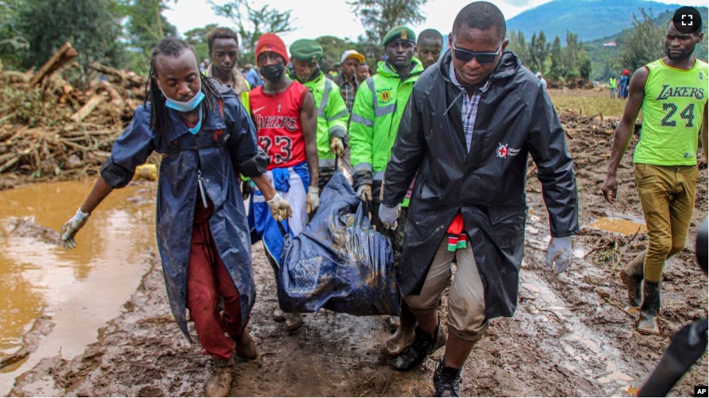 FILE - Kenya Red Cross workers and volunteers, carry a man's body retrieved from mud, after floodwater washed away houses, in Kamuchiri Village Mai Mahiu, Nakuru County, Kenya, Tuesday, April 30, 2024. (AP Photo/Patrick Ngugi, File)