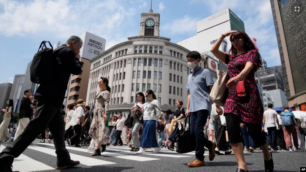 FILE - People walk across a street at the Ginza district of Tokyo, Japan, Tuesday, May 21, 2024.(AP Photo/Shuji Kajiyama)(AP Photo/Shuji Kajiyama)