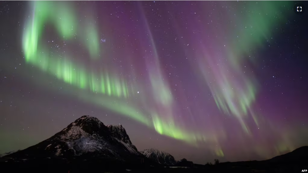 FILE - This picture shows northern lights (Aurora Borealis) over the mountain at Utakleiv on March 3, 2024 in Lofoten Islands. (Photo by Olivier MORIN / AFP)