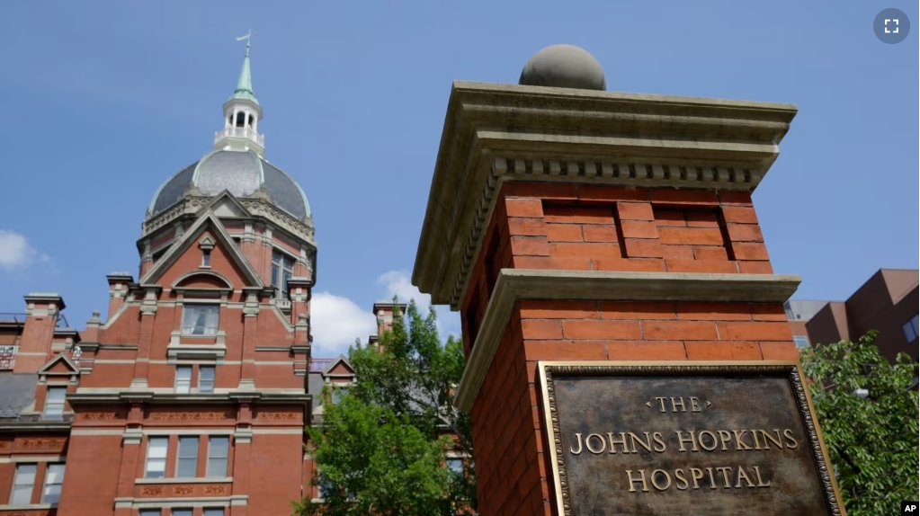 FILE - A sign stands in front of part of the Johns Hopkins Hospital complex, July 8, 2014, in Baltimore. Most medical students at Johns Hopkins University will no longer pay tuition thanks to a $1 billion gift from Bloomberg Philanthropies. (AP Photo/Patrick Semansky, file)