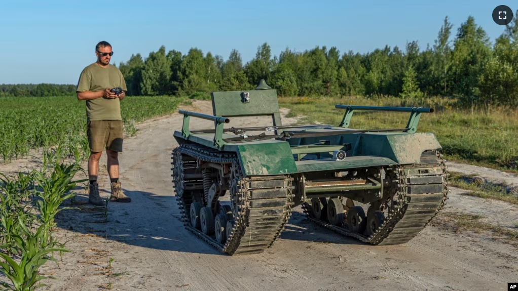 Andrii Denysenko, CEO of design and production bureau "UkrPrototyp", stands by Odyssey, an 800-kilogram (1,750-pound) ground drone prototype, at a corn field in northern Ukraine, Friday, June 28, 2024. (AP Photo/Anton Shtuka)