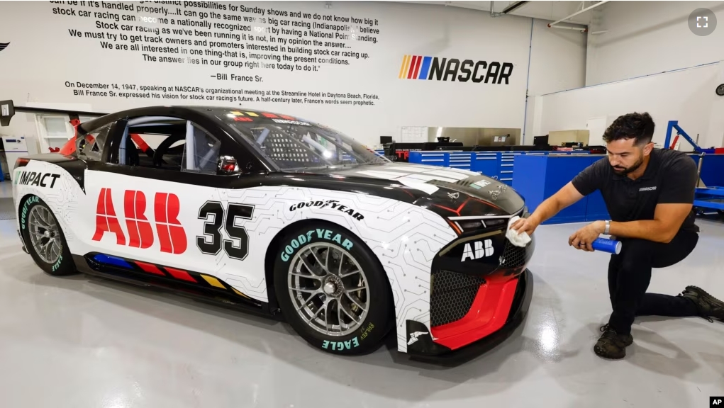 CJ Tobin, senior engineer of vehicle systems, cleans a prototype of the first electric racecar at the NASCAR R&D Center in Concord, N.C., Monday, July 1, 2024. (AP Photo/Nell Redmond)