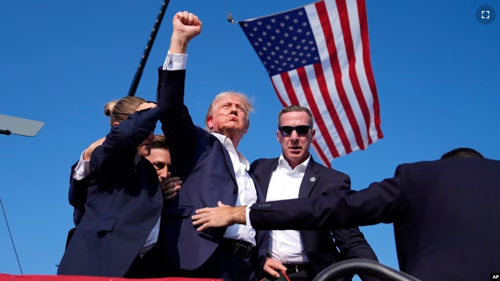 Republican presidential candidate former President Donald Trump gestures as he is surrounded by U.S. Secret Service agents as he leaves the stage at a campaign rally, Saturday, July 13, 2024, in Butler, Pa. (AP Photo/Evan Vucci)