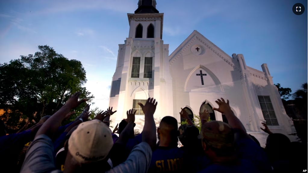 Members of the Omega Psi Phi Fraternity lead people in prayer outside the Emanuel African Methodist Episcopal Church after a memorial for nine people who were shot and killed in Charleston, S.C., Friday, June 19, 2015. (AP Photo/Stephen B. Morton, File)
