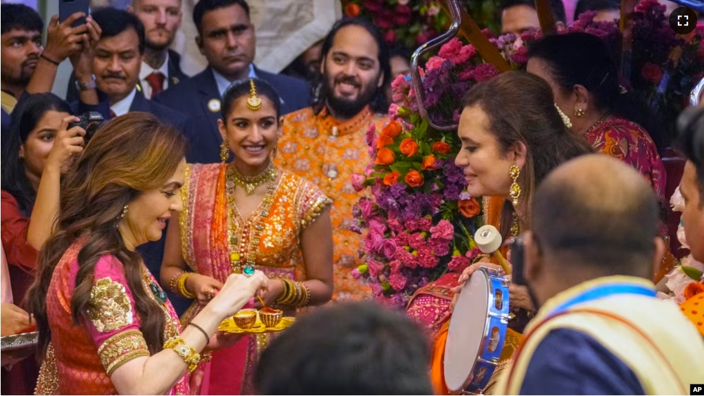 Nita Ambani, left, wife of Reliance Industries Chairman Mukesh Ambani along with his son Anant Ambani, right, and his fiancée Radhika Merchant, center, greets guests during pre-wedding ceremony at their residence Antilia in Mumbai, India, July 3, 2024.(AP Photo/Rafiq Maqbool)