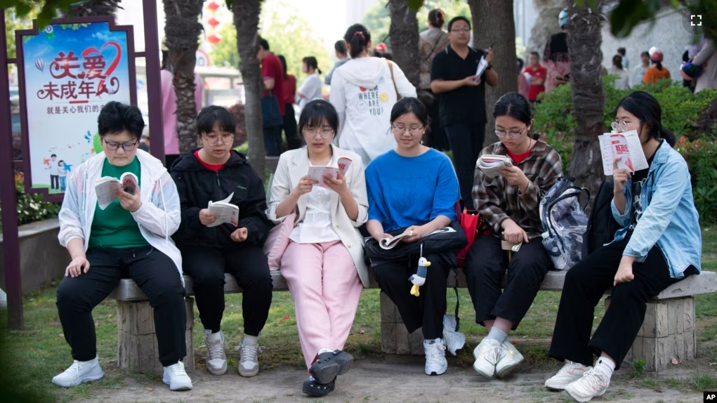 FILE - Students review their exam preparation materials in the last minutes before the National College Entrance Exam, or Gaokao, outside an exam venue in Hai'an city in east China's Jiangsu province on June 7, 2024. (Chinatopix via AP)