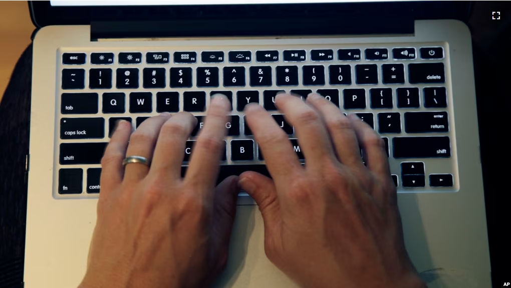 FILE - This Monday, June 19, 2017, photo shows fingers on a laptop keyboard in North Andover, Mass. (AP Photo/Elise Amendola)