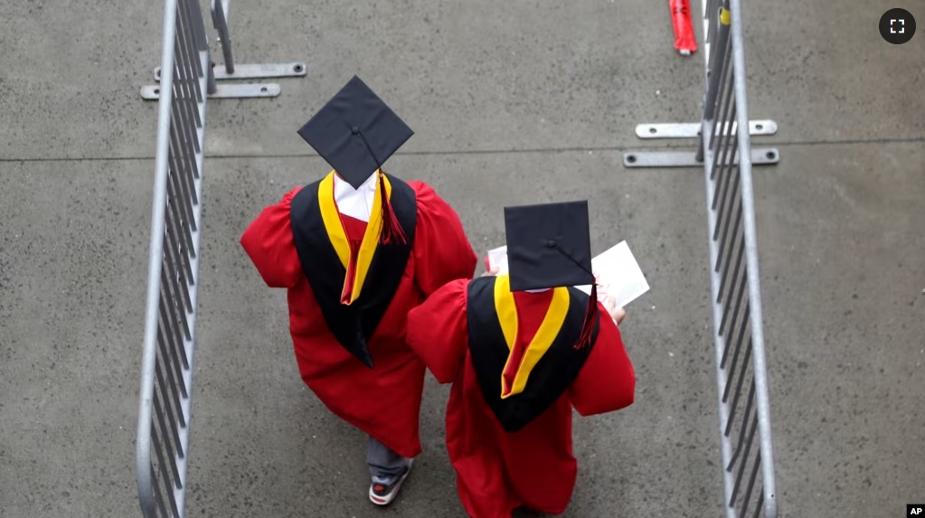 FILE - In this May 13, 2018, file photo, new graduates walk at the start of the Rutgers University graduation ceremony in New Jersey. Americans are saying the U.S. higher education system is headed in the “wrong direction.” (AP Photo/Seth Wenig, File)