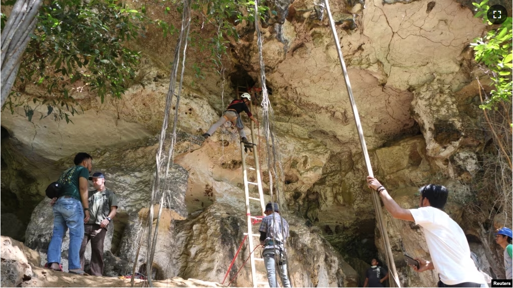 FILE - Researchers from Indonesia's National Research Centre for Archaeology and Griffith University, work in a limestone cave in South Sulawesi, Indonesia December 4, 2019. (Courtesy of Indonesia's National Research Centre for Archaeology/Griffith University via REUTERS)