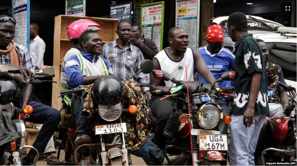 Drivers of motorcycle taxis, known locally as boda-bodas, ride with passengers on a street in Kampala, Uganda, on July 18, 2024. (AP Photo/Hajarah Nalwadda )