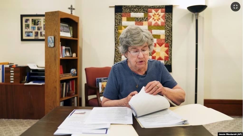 Sister Barbara McCracken looks through prior resolutions filed against various corporations, including Alphabet, Meta, Netflix and Chevron, at the Mount St. Scholastica Benedictine monastery in Atchison, Kan., Tuesday, July 16, 2024. (AP Photo/Jessie Wardarski)