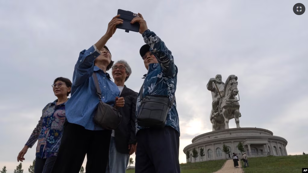 Tourists take photos near the 40-meter-tall stainless steel statue of Genghis Khan, a national hero who amassed power to become the leader of the Mongols in the early 13th century on the outskirts of Ulaanbaatar, Mongolia on July 1, 2024. (AP Photo/Ng Han Guan)