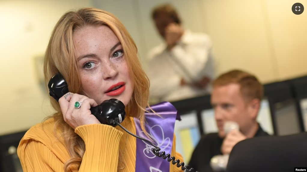 FILE - U.S. actress Lindsay Lohan speaks on a telephone during a charity day at BGC Partners in the Canary Wharf business district in London, Britain September 12, 2016. (REUTERS/Toby Melville)