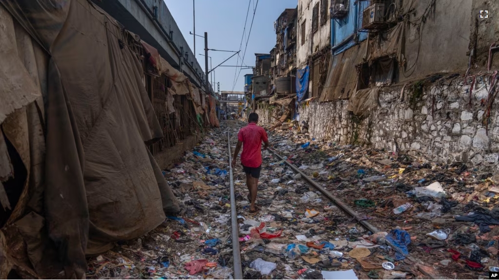 FILE - A man walks on a railway track littered with plastic and other waste materials on Earth Day in Mumbai, India, April 22, 2024. (AP Photo/Rafiq Maqbool, File)