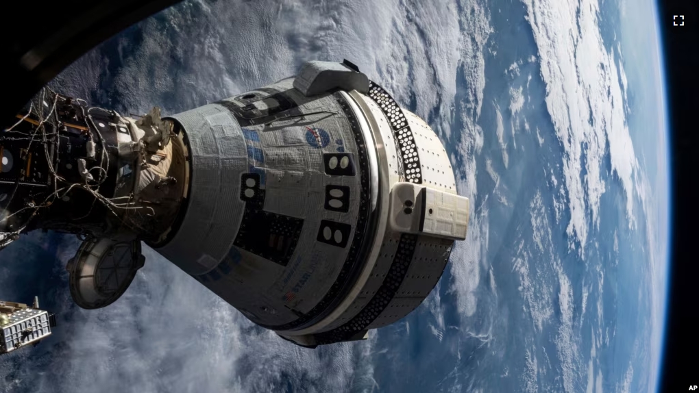 In this photo provided by NASA, Boeing's Starliner spacecraft is docked to the Harmony module of the International Space Station on July 3, 2024, seen from a window on the SpaceX Dragon Endeavour spacecraft docked to an adjacent port. (NASA via AP)