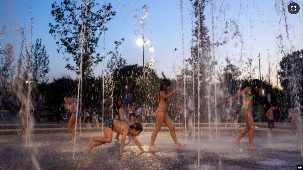 FILE - Children cool off as they play on a fountain at Stavros Niarchos Foundation Cultural Center, in Athens, Greece, July 18, 2024. (AP Photo/Petros Giannakouris)