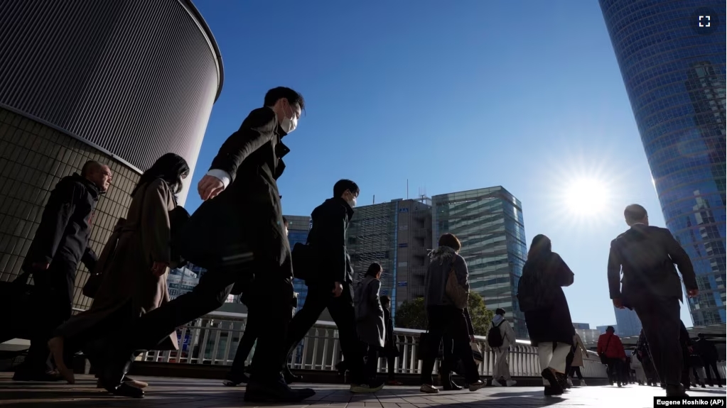 FILE - Commuters walk in a passageway during a rush hour at Shinagawa Station, Feb. 14, 2024, in Tokyo. (AP Photo/Eugene Hoshiko, File)