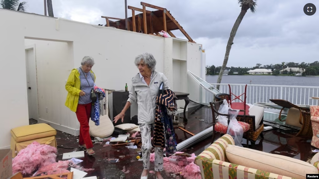 A Bayou West resident and friend try to salvage items from her home after an apparent tornado touched down on the central beach community after Hurricane Milton in Vero Beach, Fla., Oct.11, 2024. (Kaila Jones/USA Today Network via Reuters)