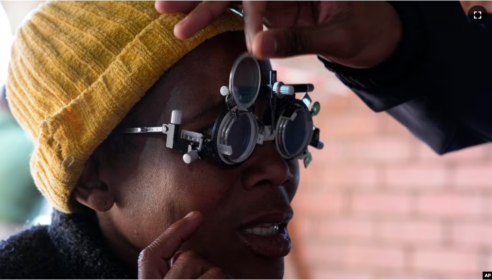 A patient eyes are tested for lenses to be made for a new pair of glasses outside the Phelophepa eye clinic carriage, in Tembisa, east of Johannesburg, South Africa, Thursday, Aug. 22, 2024. (AP Photo/Themba Hadebe)