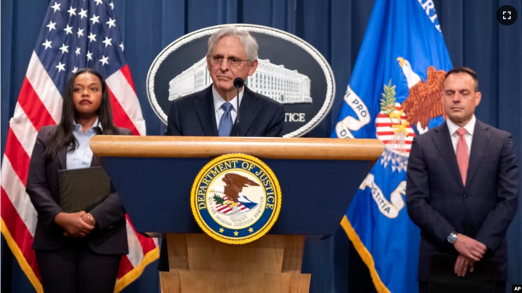 Attorney General Merrick Garland, center, is joined by other Justice Department officials at a news conference at the Department of Justice, Tuesday, Sept. 24, 2024, in Washington. (AP Photo/Mark Schiefelbein)