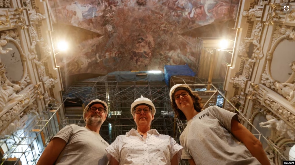 Jose Luis Regidor, restorer and director of the project, joins Pilar Roig Picazo and Pilar Bosch Roig for a picture at the Church of Santos Juanes, in Valencia, Spain, September 16, 2024. (REUTERS/Eva Manez)