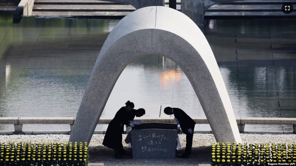 FILE - Kazumi Matsui, right, mayor of Hiroshima bows, at Hiroshima Memorial Cenotaph in Hiroshima, western Japan, Aug. 6, 2015. The Nobel Peace Prize has been awarded to a Japanese organization of atomic bomb survivors. (AP Photo/Eugene Hoshiko, File)