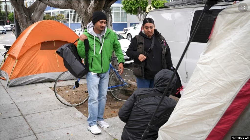 Members of the San Francisco Homeless Outreach Team talk to a homeless person in the Mission District, Sept. 10, 2024, in San Francisco. (AP Photo/Terry Chea)