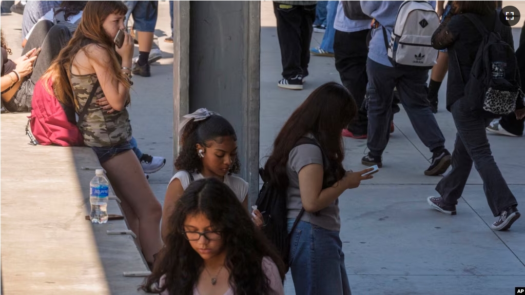 In this file photo, students use their cellphones as they leave for the day the Ramon C. Cortines School of Visual and Performing Arts High School in downtown Los Angeles, Aug. 13, 2024. (AP Photo/Damian Dovarganes, File)