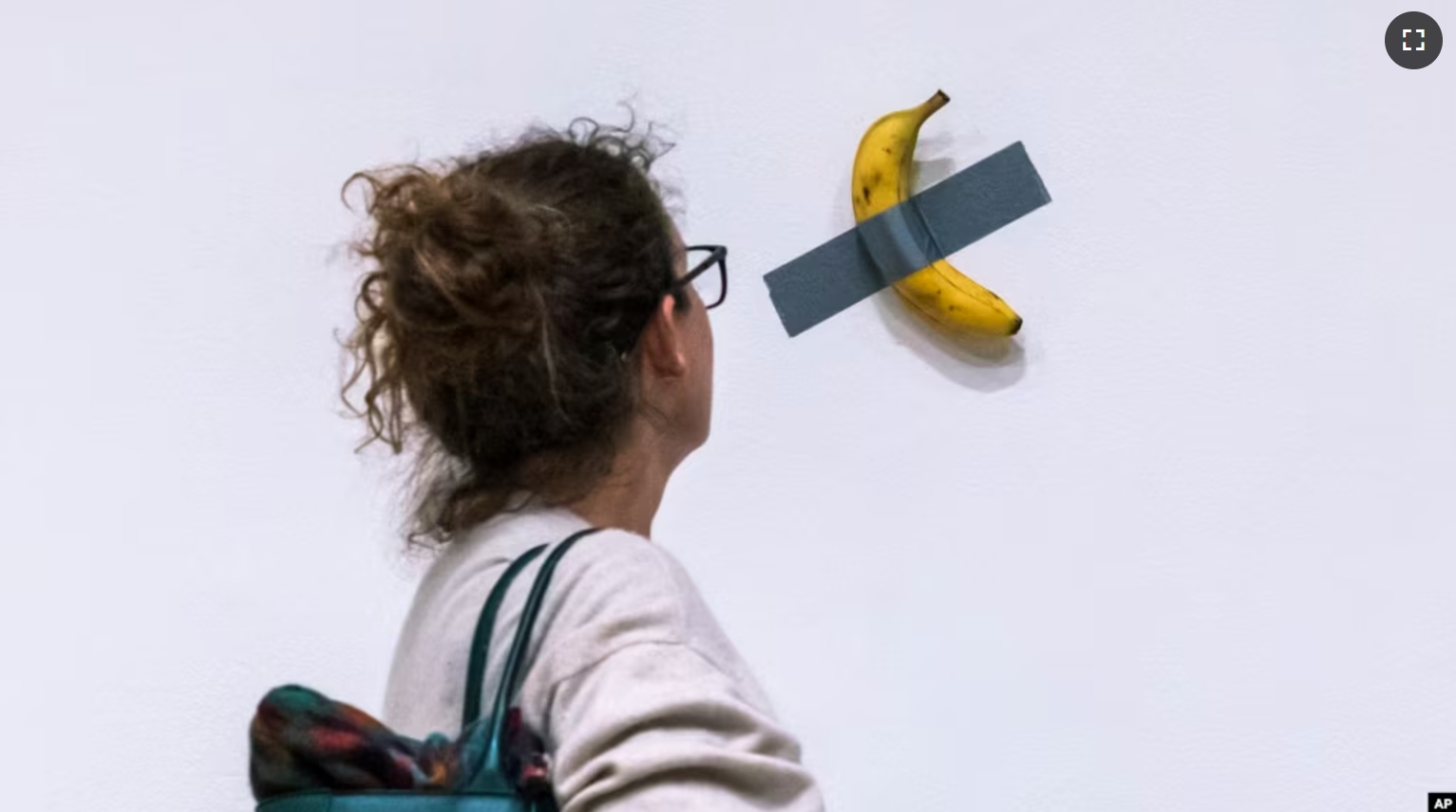 In this file photo, a woman looks at artist Maurizio Cattelan's piece of art "Comedian" during an auction preview at Sotheby's in New York, Monday, Nov. 11, 2024. (AP Photo/Eduardo Munoz Alvarez, File)