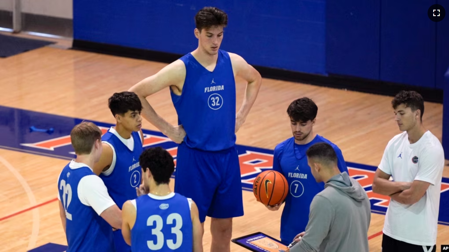 Olivier Rioux, back center, a 2.4-meter-tall college basketball player at Florida, gathers with coaches and teammates at the team's practice, Friday, Oct. 18, 2024, in Gainesville, Fla. (AP Photo/John Raoux)