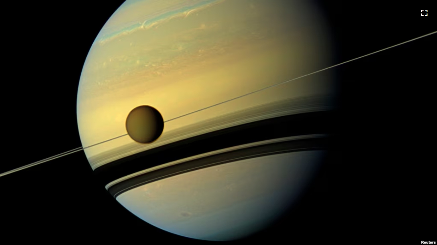 Titan, Saturn's largest moon appears before the planet as it undergoes seasonal changes in this natural color view from NASA's Cassini spacecraft in this handout released by NASA August 29, 2012. (REUTERS/ NASA/JPL-Caltech/SSI)