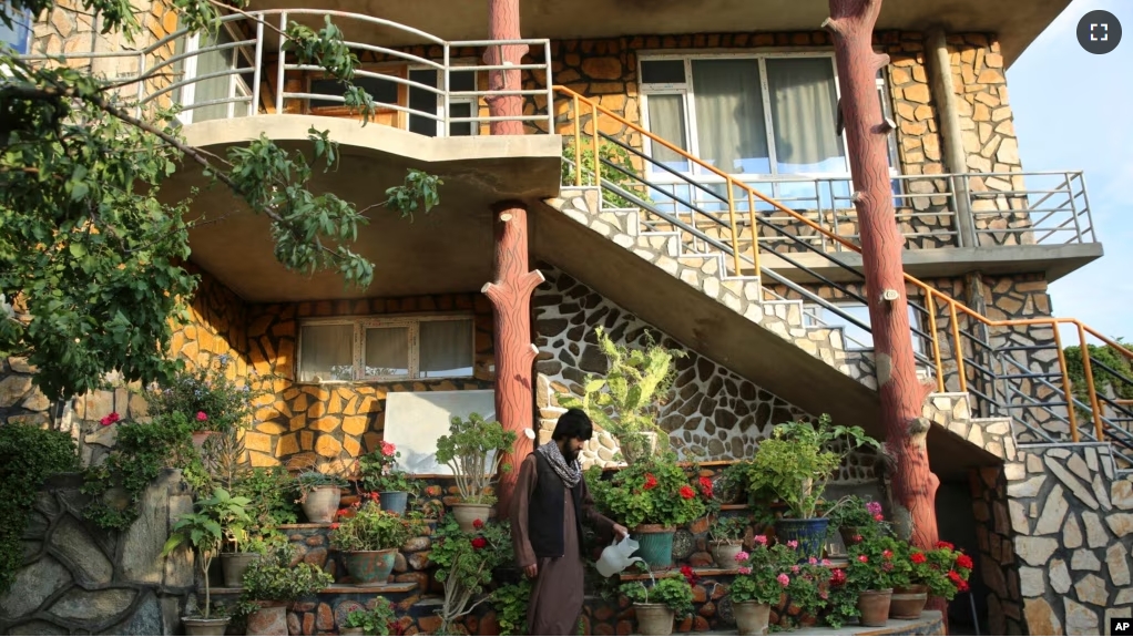 A man waters flowers outside a luxury house in the city of Kabul, Afghanistan, Sept. 29, 2024. (AP Photo/Siddiqullah Alizai)