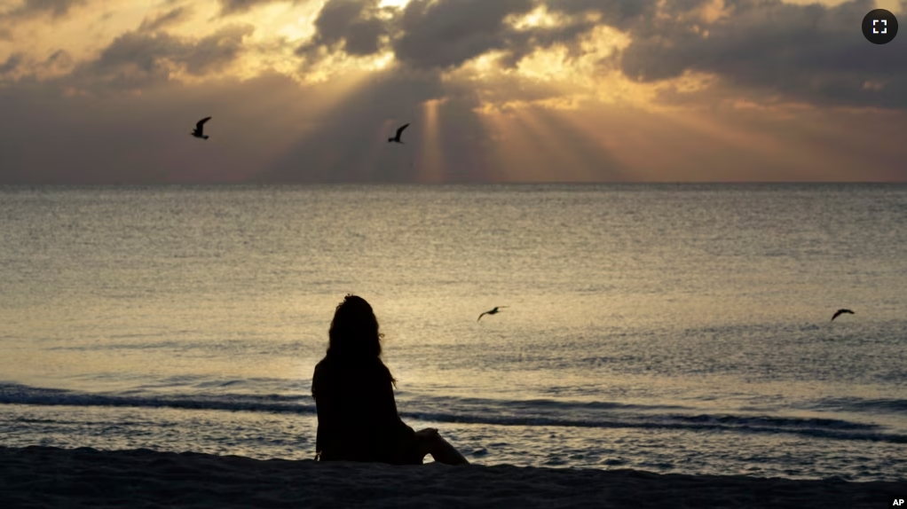 FILE - A woman meditates on the beach in Miami, Florida, April 28, 2010. According to a study published on Nov. 9, 2022 in the journal JAMA Psychiatry, mindfulness meditation worked as well as a standard drug for treating anxiety. (AP Photo/Lynne Sladky, File)