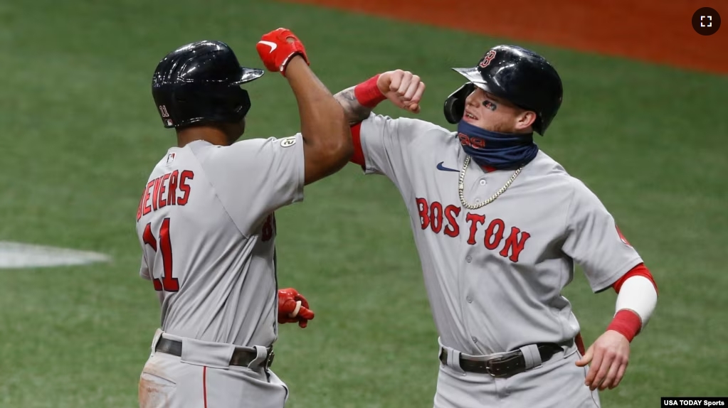 FILE - Boston Red Sox third baseman Rafael Devers gets an elbow bump from the batboy (right) after hitting a two-run home run at Tropicana Field, Sept. 10, 2020, St. Petersburg, Florida. (Reinhold Matay-USA TODAY Sports)