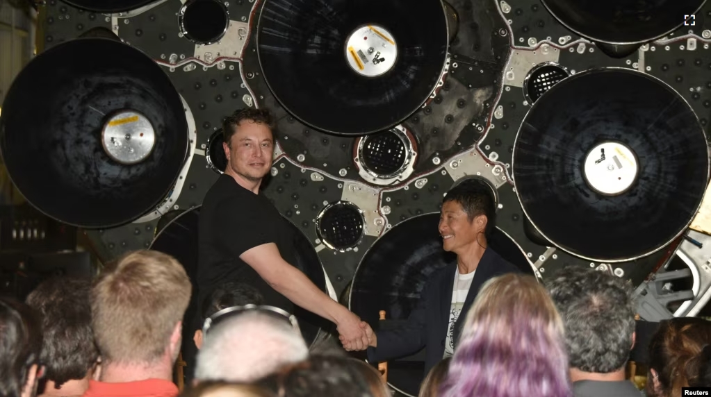 FILE - SpaceX CEO Elon Musk (L) shakes hands with Japanese billionaire Yusaku Maezawa who was introduced as the first SpaceX private passenger to circle the moon, in Hawthorne, California September 17, 2018. (REUTERS/Gene Blevins)