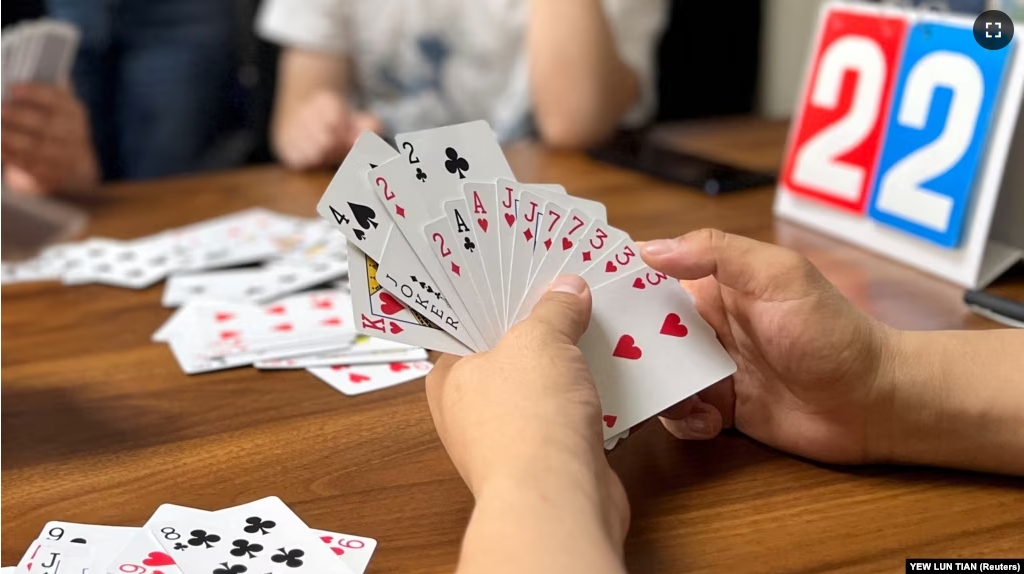 FILE - Finance professionals learn how to play guandan, a poker-like card game, during a training session in Beijing, China, August 6, 2023. (REUTERS/Yew Lun Tian)