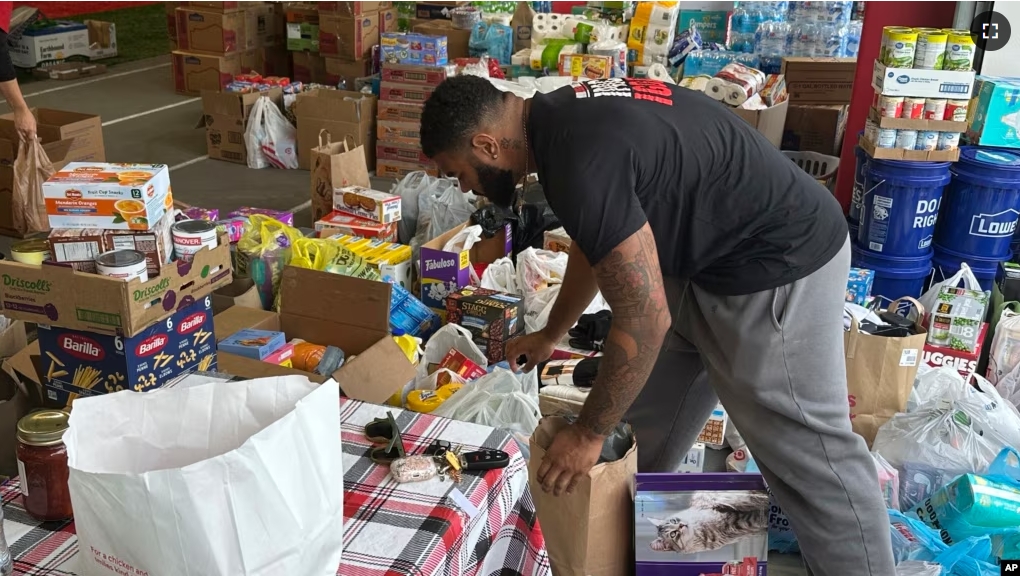 FILE - N.C. State defensive end Davin Vann works among the donations collected to help Hurricane Helene victims in western North Carolina, Wednesday, Oct. 2, 2024 in Raleigh, N.C. (AP Photo/Aaron Beard)