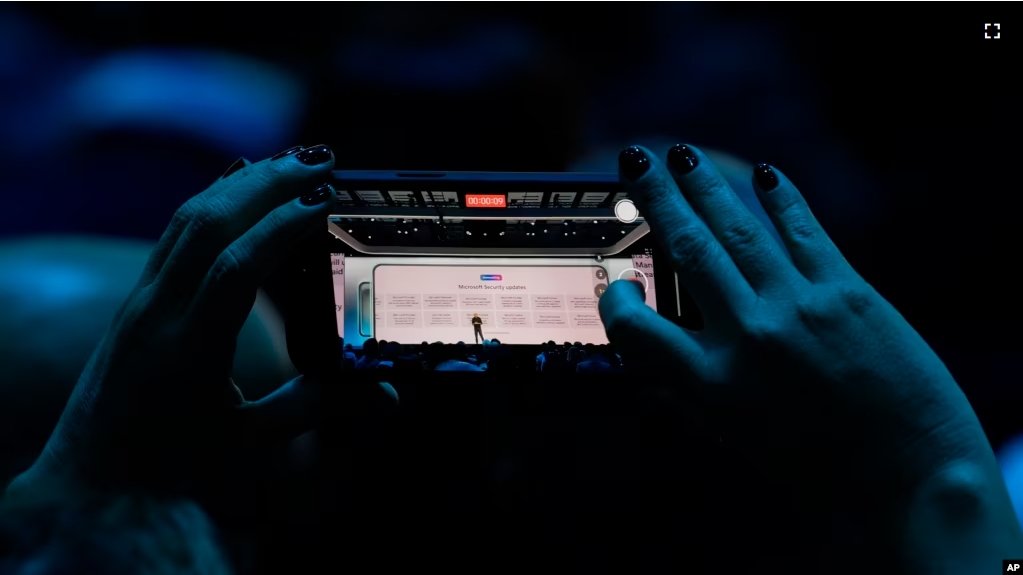 FILE - An attendee at the Microsoft Ignite conference records an address on Nov. 19, 2024, in Chicago. (AP Photo/Charles Rex Arbogast, File)