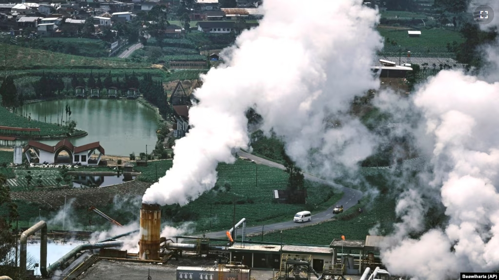 Cars drive on a road as steam rises from a geothermal power plant in Dieng, Central Java, Indonesia, Nov. 15, 2024. (AP Photo/Beawiharta)