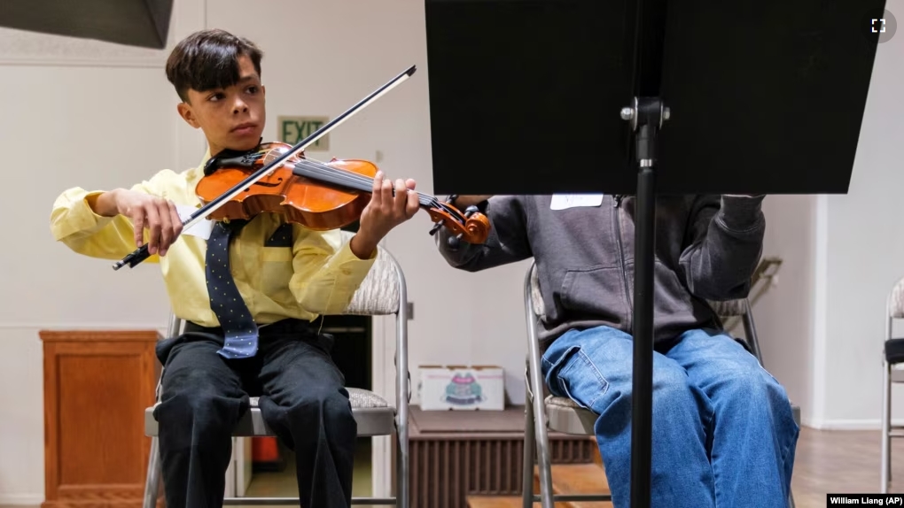 Giovanni Vazquez plays the violin during a string orchestra rehearsal at New Hope Presbyterian Church on Wednesday, Oct. 16, 2024, in Anaheim, California. (AP Photo/William Liang)