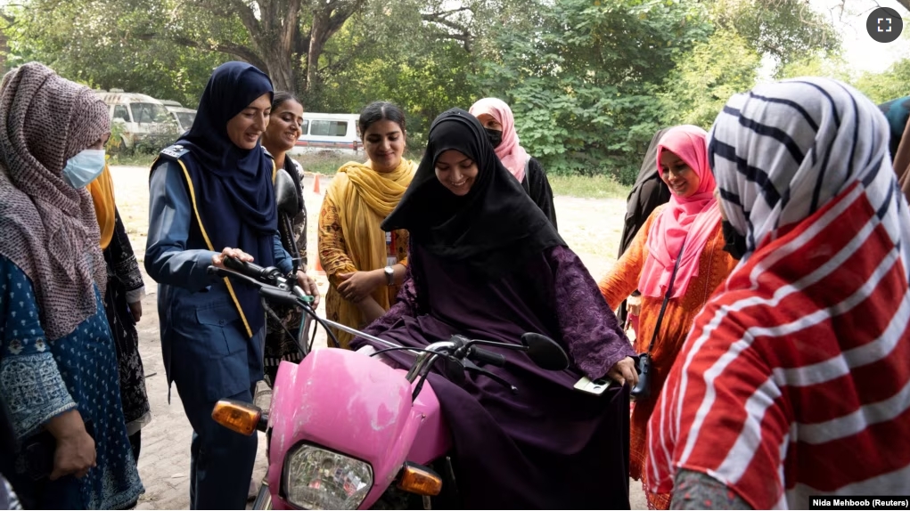 Humaira Rafaqat teaches women how to ride a bike while wearing an abaya, during a training session as part of the "Women on Wheels" program organized by the traffic police department in Lahore, Pakistan, October 1, 2024. (REUTERS/Nida Mehboob)