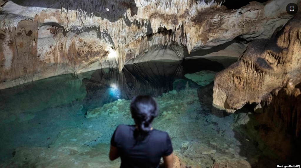 FILE - Maribel Ek, guardian of the cenotes, rests inside the Santa Maria cenote, in Homun, Mexico, Monday, March 4, 2024. (AP Photo/Rodrigo Abd)