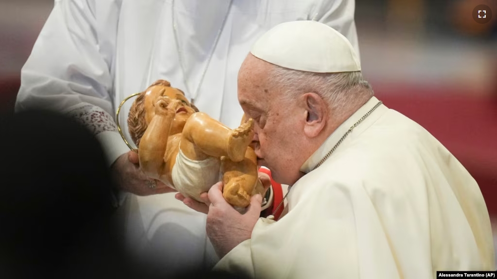 Pope Francis kisses the baby Jesus as he presides over an Epiphany mass in St.Peter's Basilica, at the Vatican, Monday, Jan. 6, 2025.