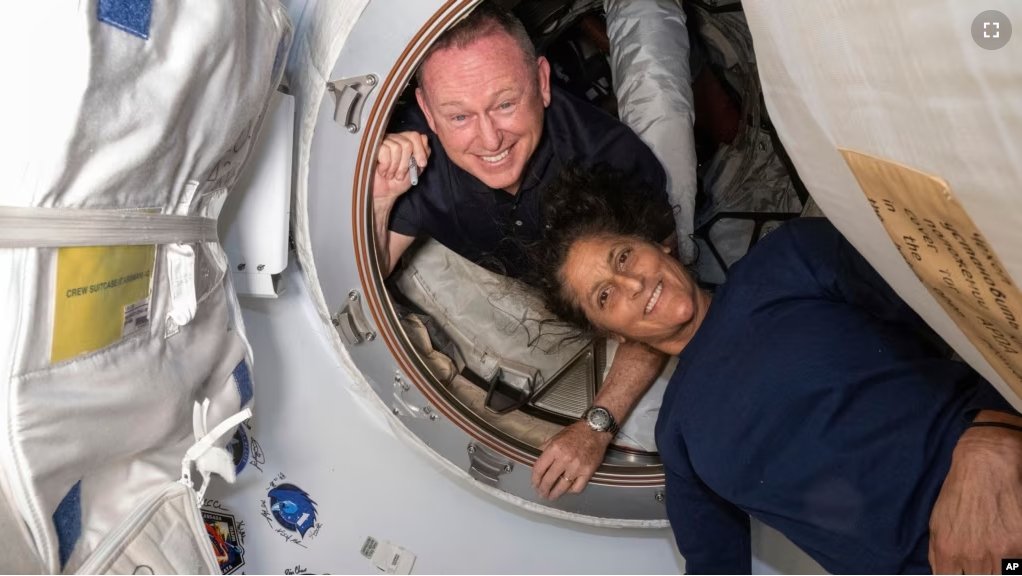 In this photo provided by NASA, Boeing Crew Flight Test astronauts Butch Wilmore, left, and Suni Williams pose inside the International Space Station's Harmony module and Boeing's Starliner spacecraft on June 13, 2024. (NASA via AP)