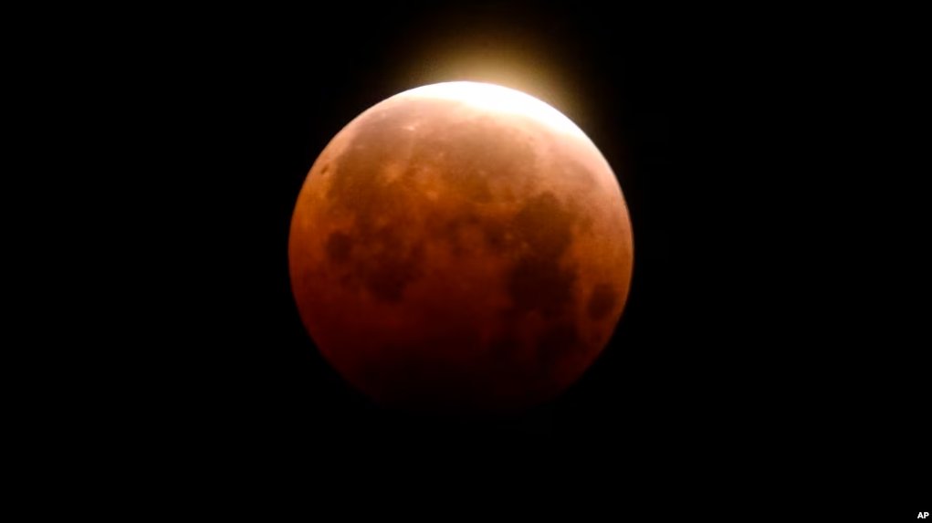 Light shines from a total lunar eclipse over Santa Monica Beach in Santa Monica, Calif., Wednesday, May 26, 2021. (AP Photo/Ringo H.W. Chiu)