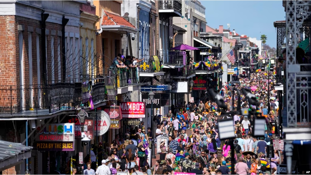 FILE - Revelers fill Bourbon Street below the balcony of the Royal Sonesta Hotel during Mardi Gras Day festivities in the French Quarter in New Orleans, Feb. 21, 2023.