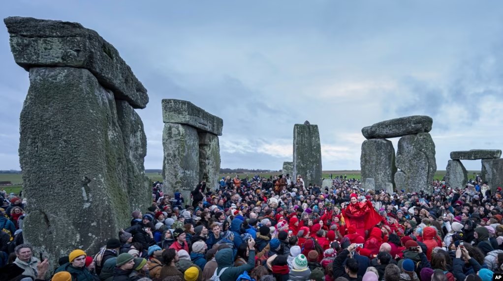 FILE - People celebrate the Winter Solstice sunrise celebrations at Stonehenge, England, Saturday, Dec. 21, 2024. (AP Photo/Anthony Upton)