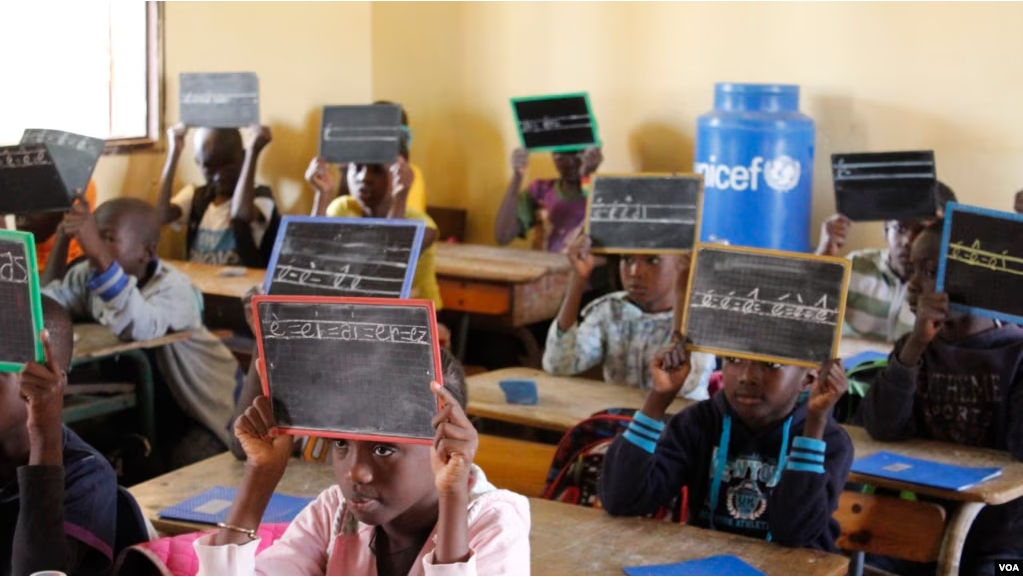 Second-graders in Alieu Samb primary school hold up chalk boards with French conjugations. Dakar, Senegal, Dec. 7 2017. (Photo: Sofia Christensen for VOA)