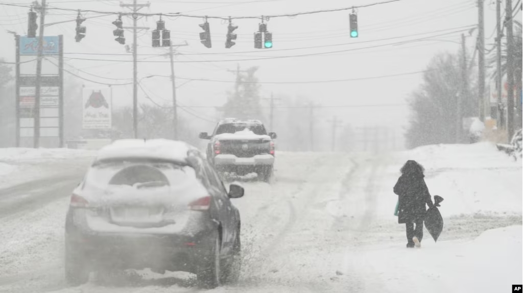 In this photo, heavy snow falls as a person walks along U.S. Route 42 in Florence, Ky., Monday, Jan. 6, 2025. (AP Photo/Carolyn Kaster, File)